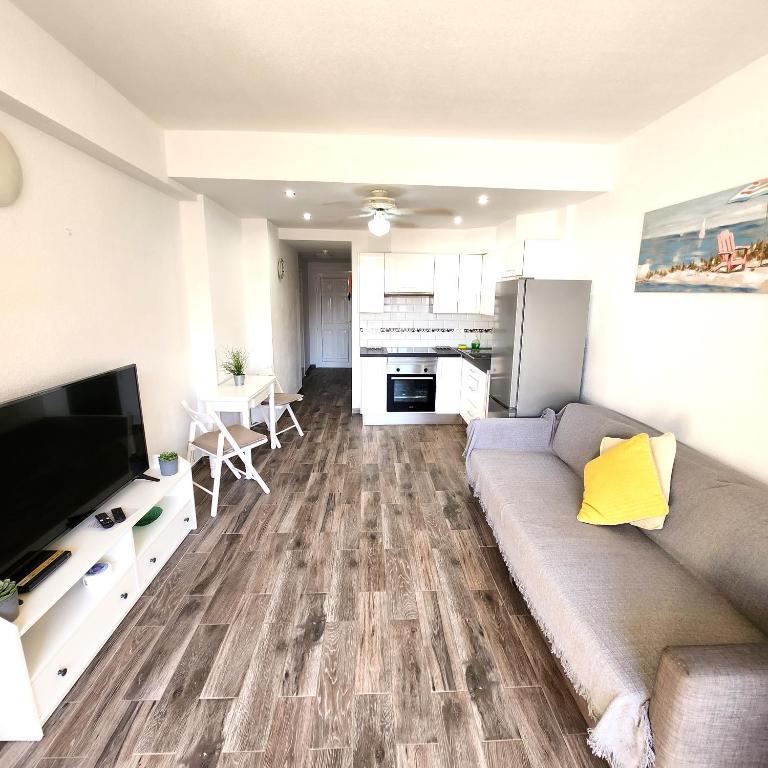 sala de estar con sofá y cocina en Castle Harbour Duplex With Pool View C115 en Los Cristianos