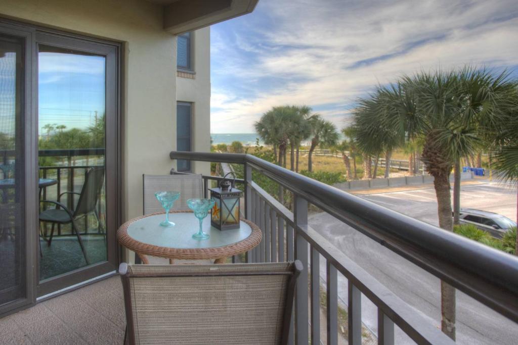 a balcony with a table with two glasses on it at 306 - Gulf Strand in St. Pete Beach