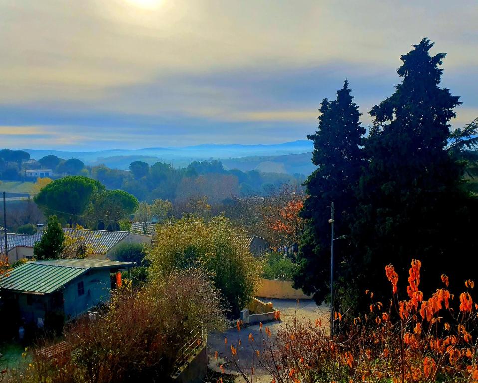 uma vista para um jardim com árvores e uma casa em Rue Basse - village house overlooking the Pyrenees em Montréal