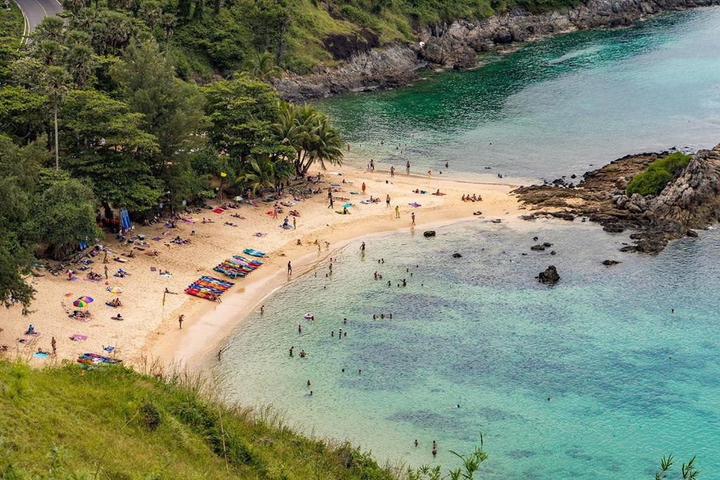 un grupo de personas en una playa en el agua en Shaman's apartment at Ya Nui beach en Phuket