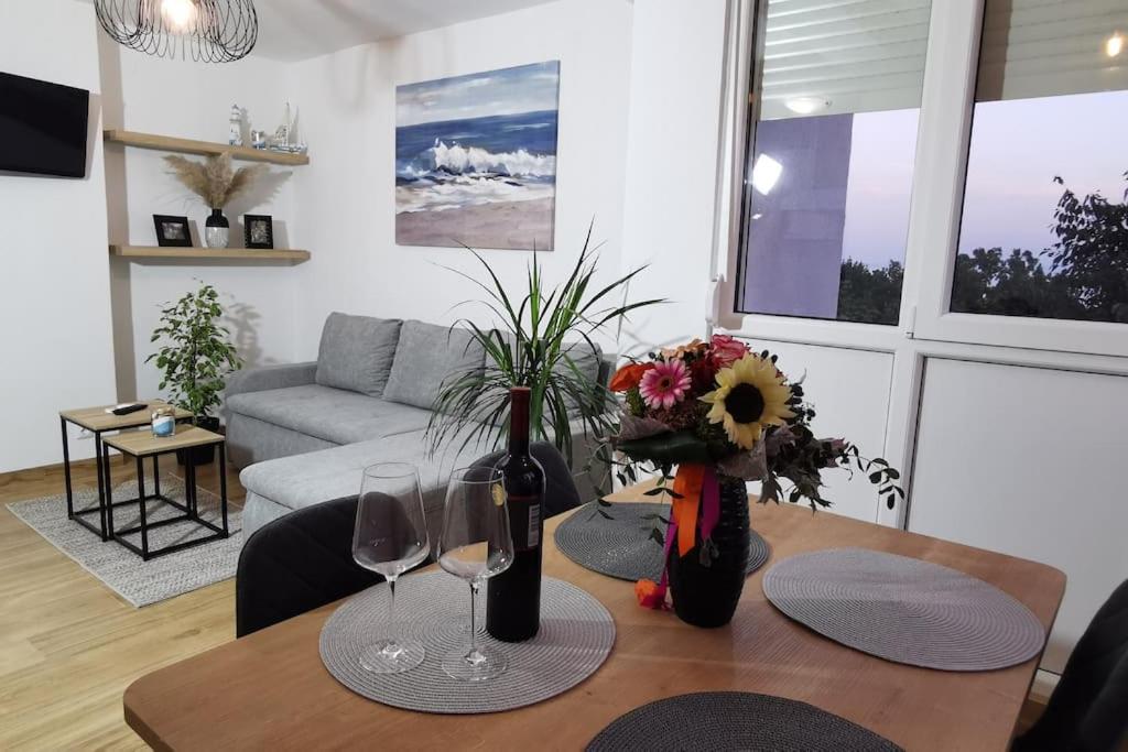 een woonkamer met een tafel met wijnglazen bij Apartman Liburna in Rijeka