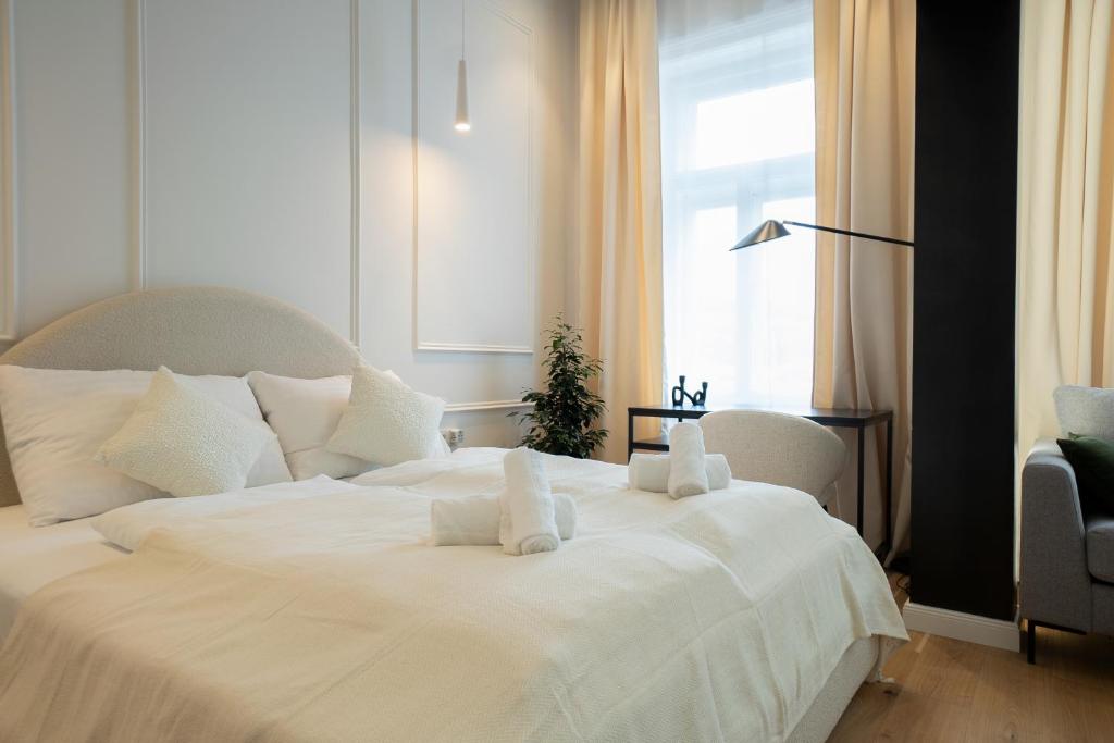 Cama blanca en habitación con ventana en Brand-new 2-room apartment with a king size bed en Viena