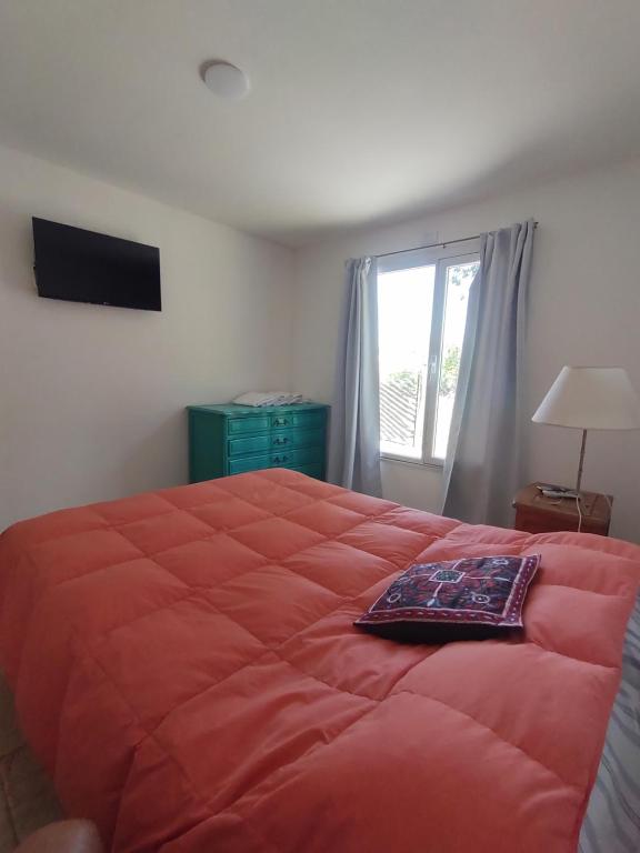 een slaapkamer met een groot rood bed en een raam bij Los nogales in Tandil