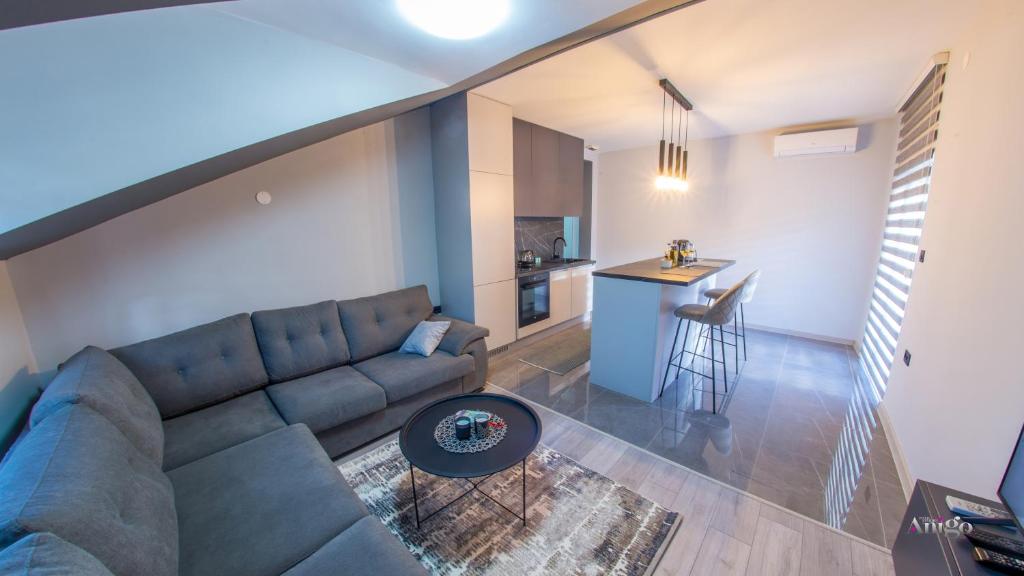 een woonkamer met een bank en een tafel bij Maxim Apartments in Mostar