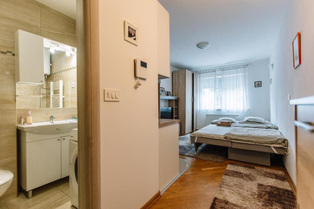 uma pequena casa de banho com uma cama e um lavatório em Studio Apartmani Donnie em Livno