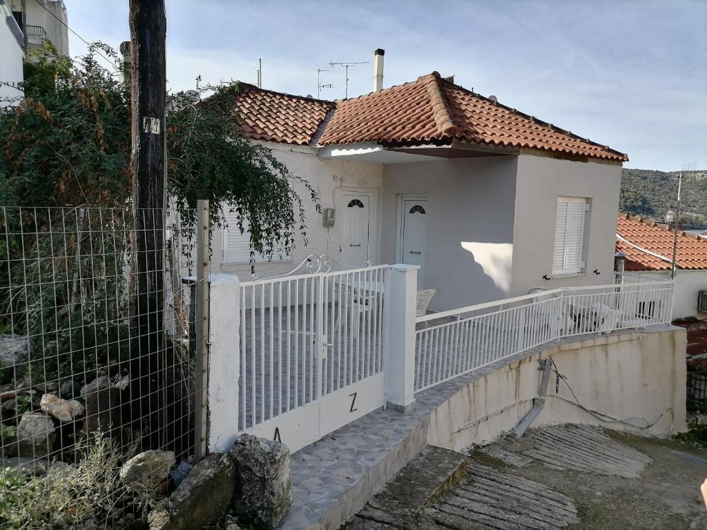 a white house with a white fence at House in Amfilochia- Μονοκατοικία in Amfilochía