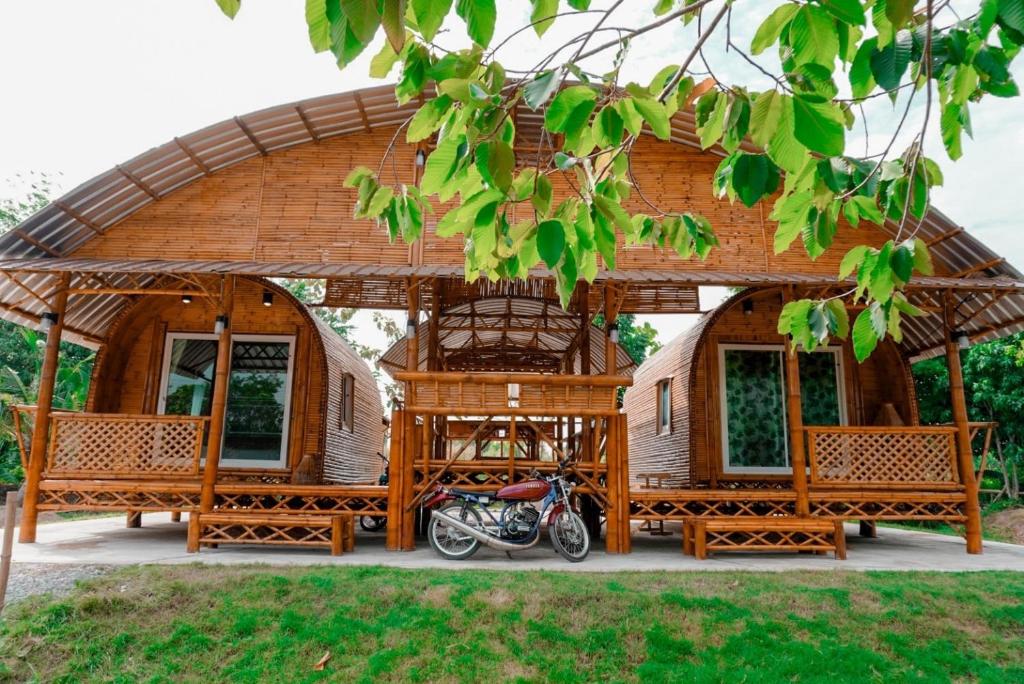 a motorcycle parked in front of a wooden gazebo at ชีวาวิลล์ ฟาร์มสเตย์ - Cheewavill farmstay in Ban Ko
