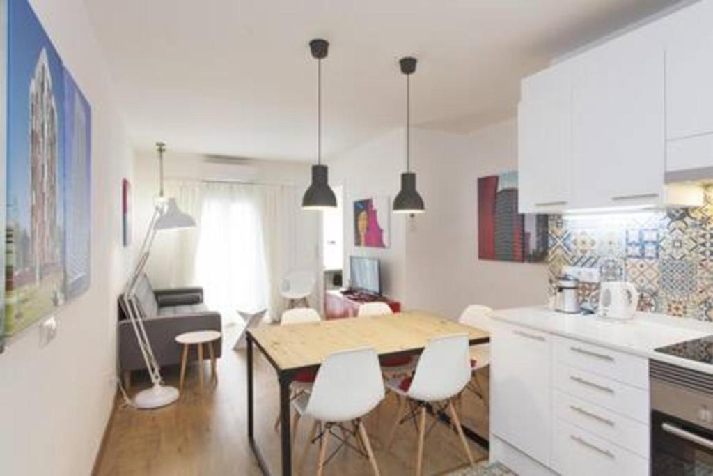 cocina con mesa y sillas en una habitación en Designer Apt near FIRA Balcony 5PPWIFISMART TV by MyRentalHost, en Hospitalet de Llobregat