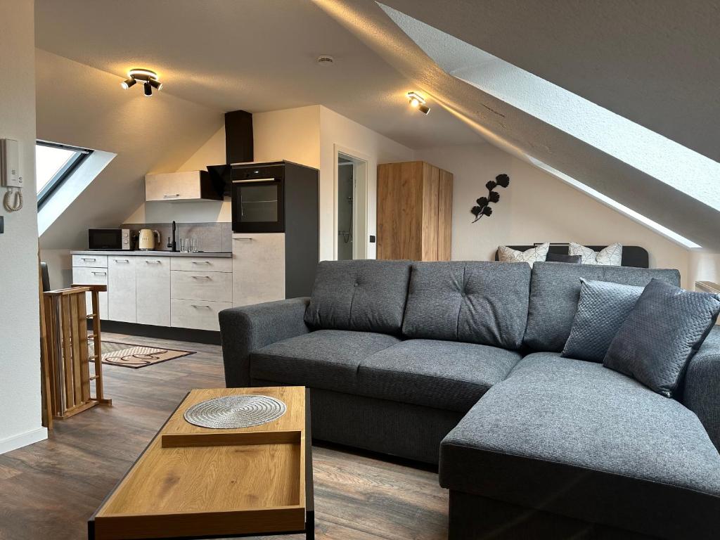 uma sala de estar com um sofá e uma cozinha em Ferienwohnung Zeitz - Weiße Elster Apartment Nr 9 em Zeitz