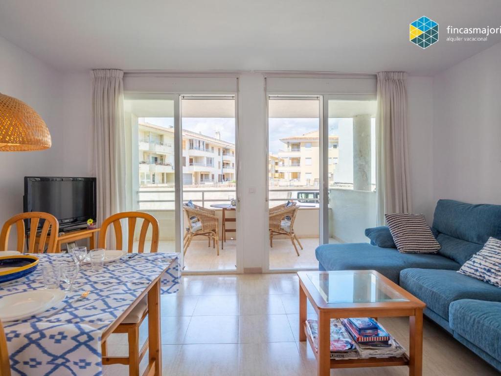 a living room with a blue couch and a table at Apartamento Sky Blue in Colònia de Sant Jordi