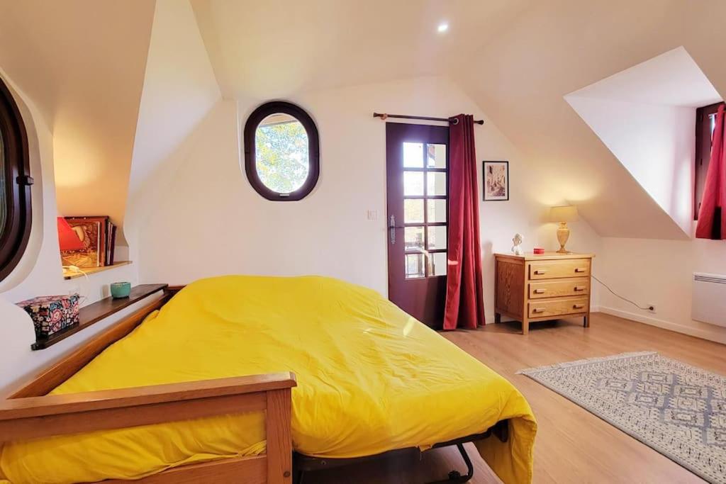 Un dormitorio con una cama amarilla y una ventana en Maison de charme au calme, en Villeneuve-sur-Bellot