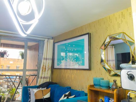 坎帕拉的住宿－Luzira Plaza，客厅配有蓝色的沙发和镜子