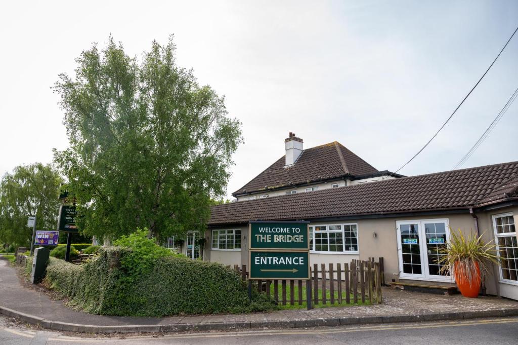 un edificio con un cartel que diga bienvenida a la entrada del puente en Bridge Inn, en Clevedon