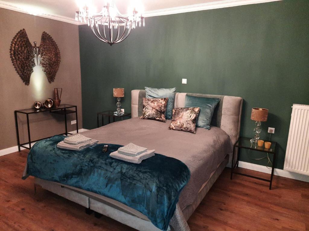 een slaapkamer met een bed in een kamer met groene muren bij Tina`s home in Gütersloh
