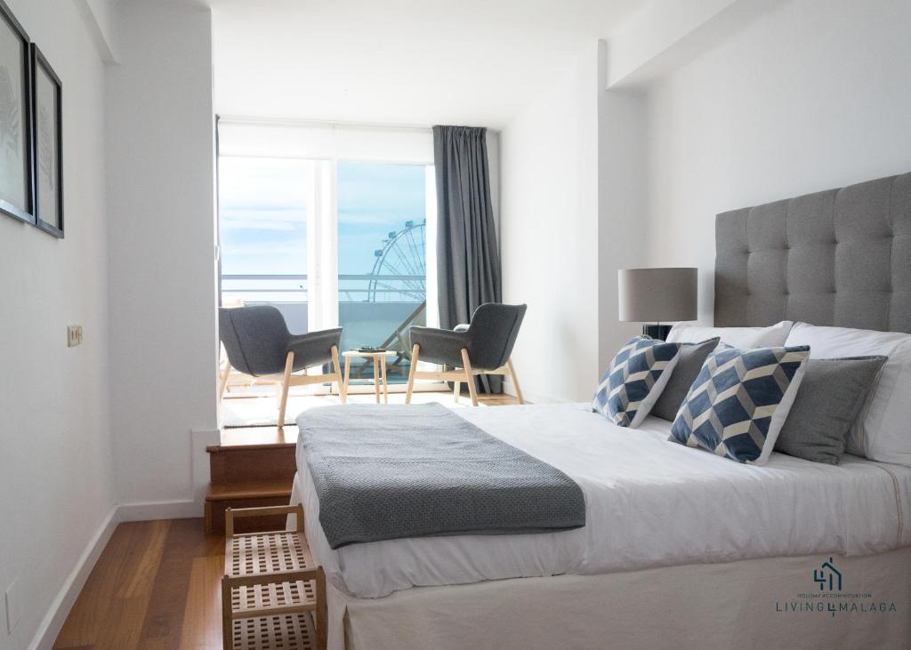 a bedroom with a bed with a view of the ocean at Living4malaga Atico Marina in Málaga