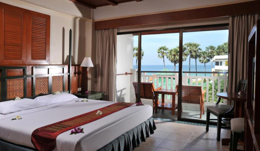 ein Schlafzimmer mit Bett und Blick auf das Meer in der Unterkunft Karon Princess Hotel SHA EXTRA Plus in Karon Beach