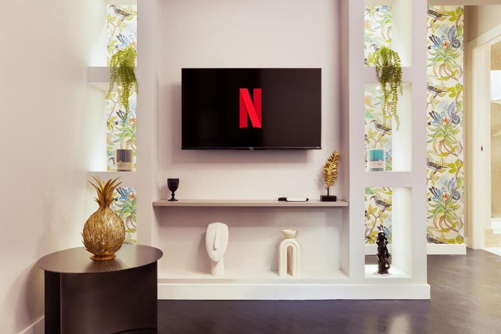 un salon avec une télévision sur un mur dans l'établissement HL Luxury Apartment - Duomo, Galleria Unione 5, à Milan