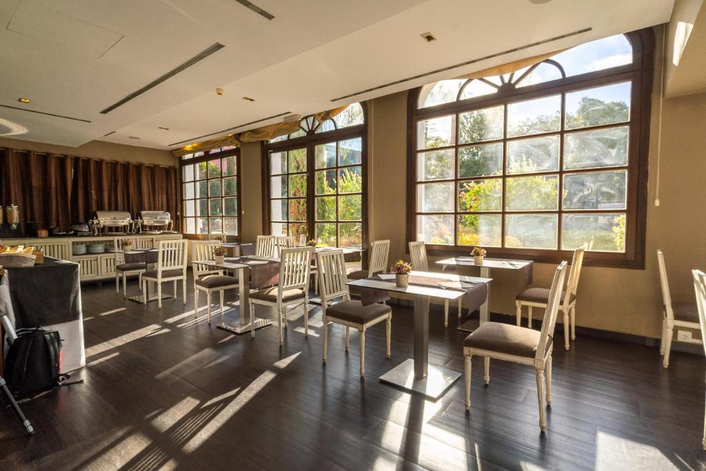Un restaurante con mesas, sillas y ventanas. en Hotel Blancafort Spa Termal, en La Garriga