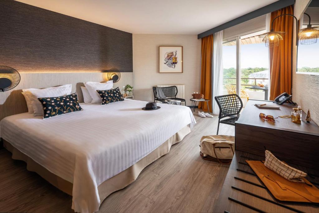 a hotel room with a large bed and a window at Hôtel Valdys Thalasso & Spa - les Pins in Saint-Jean-de-Monts