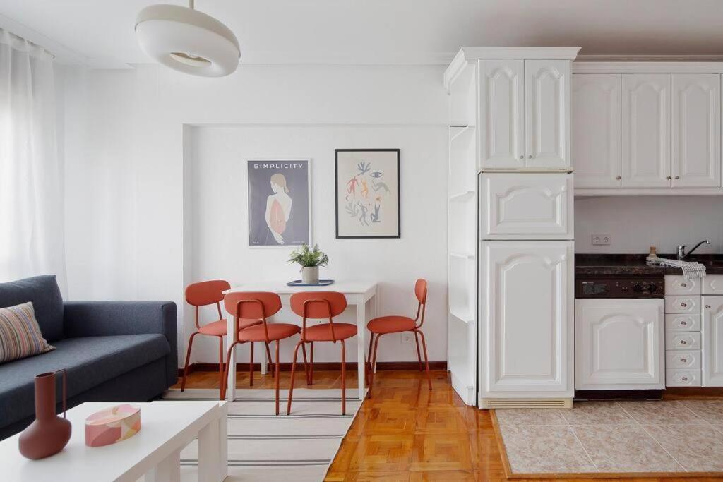 una sala de estar blanca con mesa y sillas en Apartamento Maura 2 dormitorios, en Oviedo