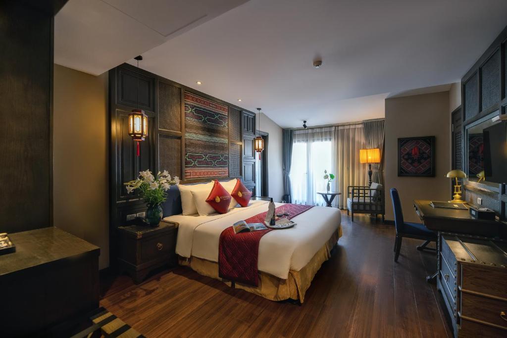 una camera d'albergo con un grande letto e una scrivania di Lotus Aroma Sapa Hotel a Sa Pa