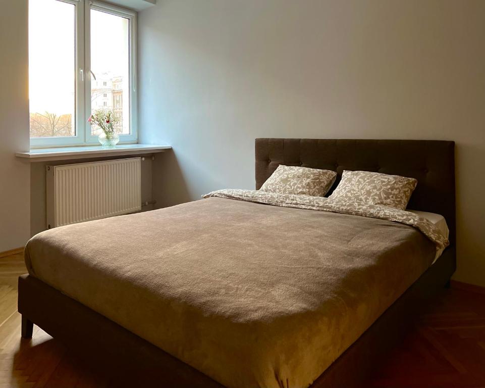 a bed with two pillows in a bedroom with a window at K22 Andersa 12 m Ratusz Arsenał in Warsaw
