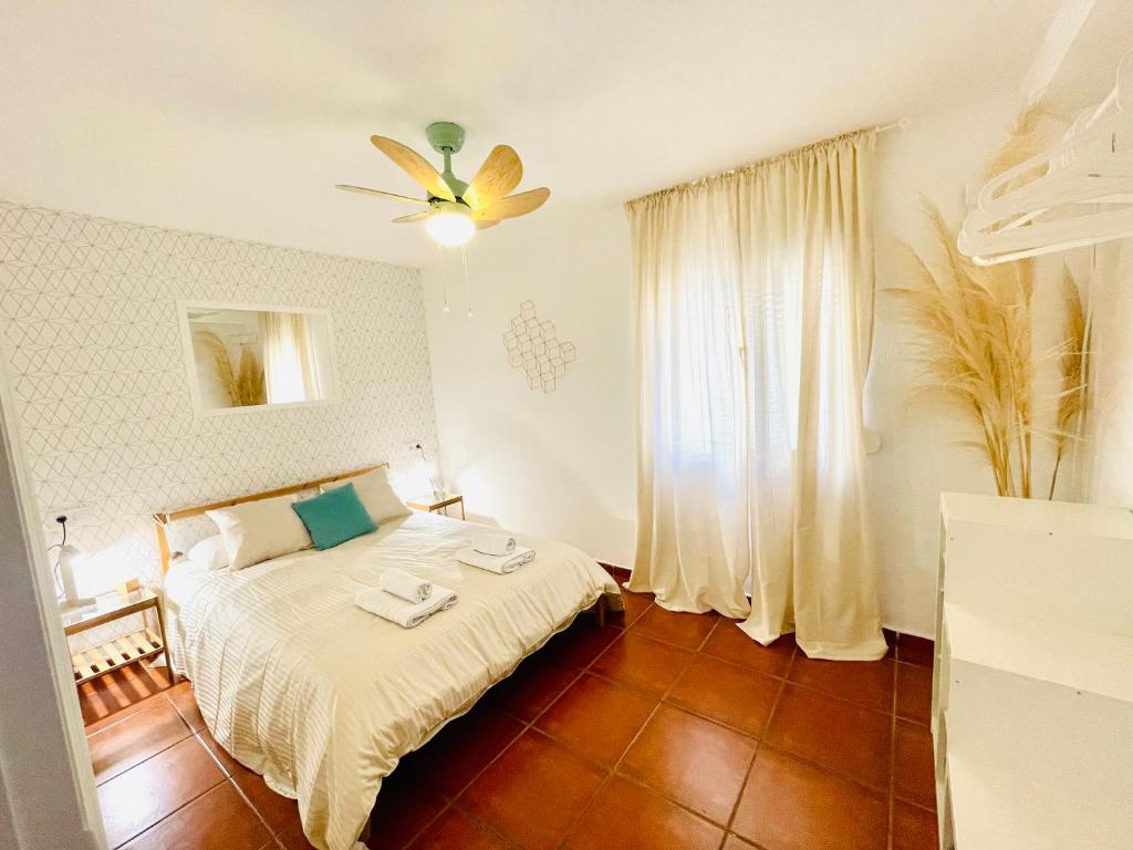 1 dormitorio con 1 cama y ventilador de techo en Welcome Málaga, en Málaga