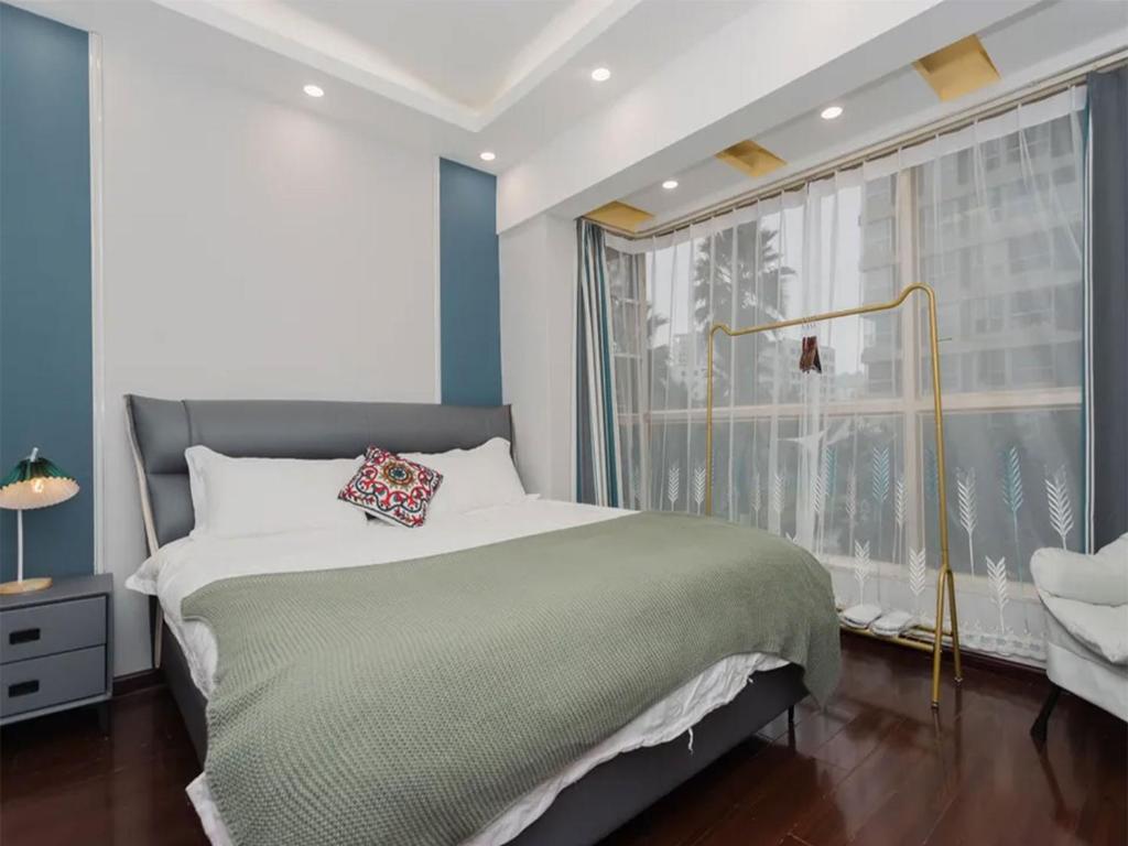 een slaapkamer met een groot bed en een raam bij Annie Apartment - only 120 metres from Metro Line 2 Exit B of Chuanxingulou in Kunming