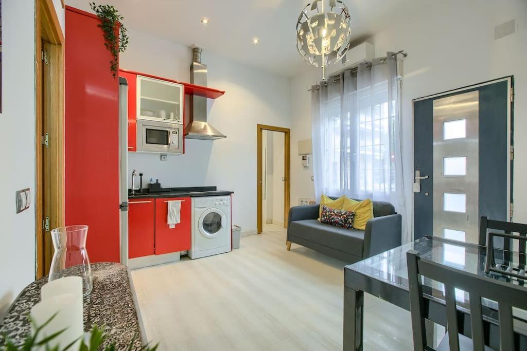 een woonkamer met een bank, een tafel en een wasmachine bij Cozy Getaway in Madrid in Madrid