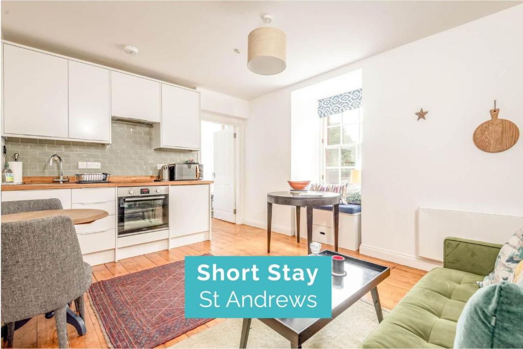a kitchen and living room with a couch and a table at Central 2 Bedroom Apartment - South Street - St Andrews in St. Andrews