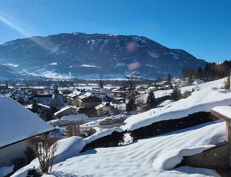 un pueblo cubierto de nieve con una montaña en el fondo en Ferienwohnung BergTime, en Weißenbach bei Liezen