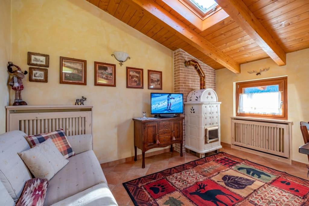 a living room with a couch and a tv at Happy Guest Apartments - Alpin Charme Colere in Colere