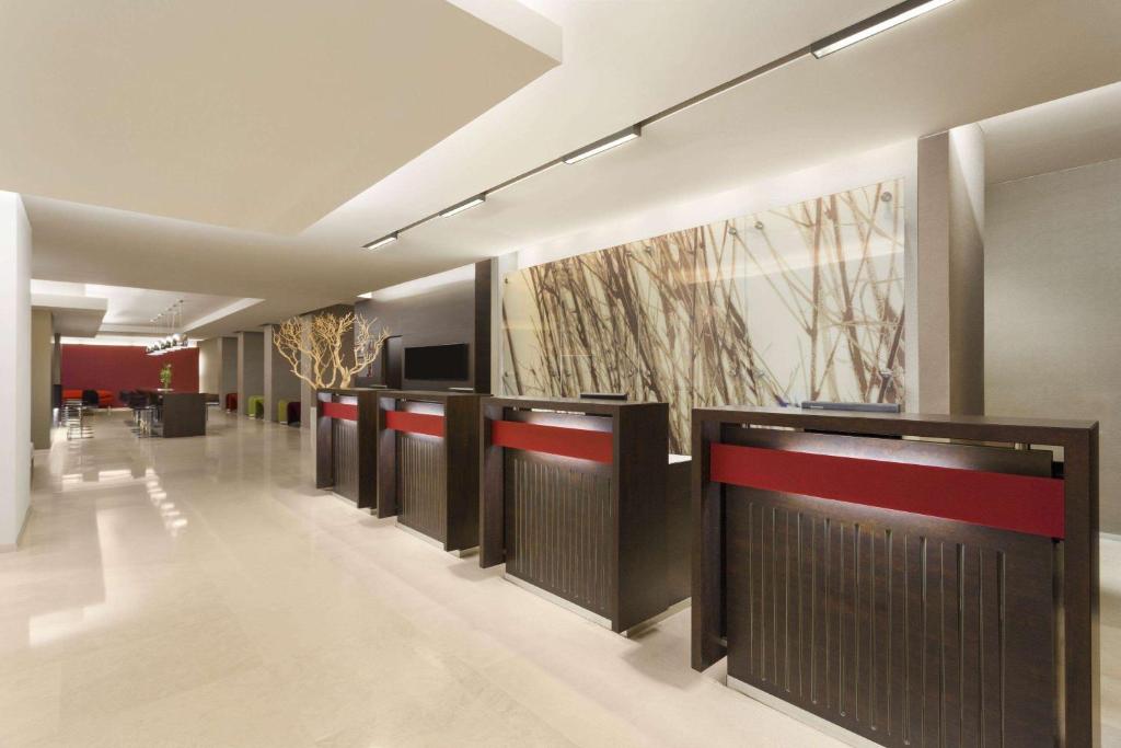 een lobby met een rij kraampjes in een gebouw bij Ramada Plaza by Wyndham Bucharest Convention Center in Boekarest