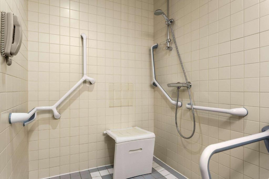 a bathroom with a shower and a toilet at Ramada Plaza by Wyndham Bucharest Convention Center in Bucharest