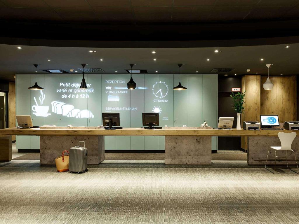 a lobby with a large desk with computers on it at ibis Berlin City Potsdamer Platz in Berlin