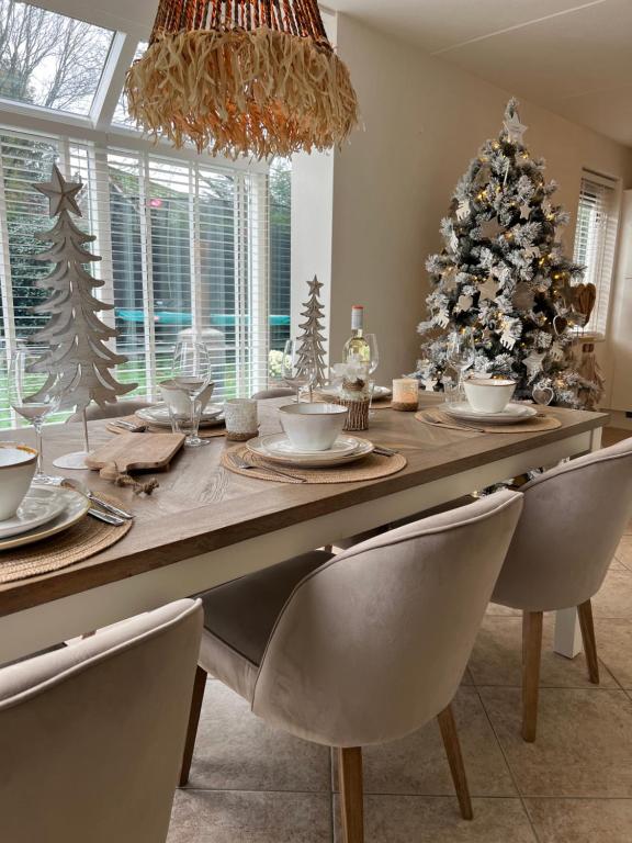 a dining room with a table with a christmas tree at Villa June Rosy in Wijchen