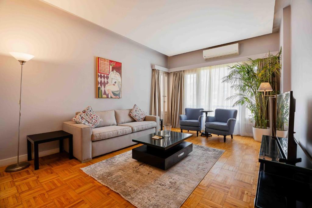 a living room with a couch and a table at Brassbell l Cozy 1 BR apartment in Zamalek in Cairo