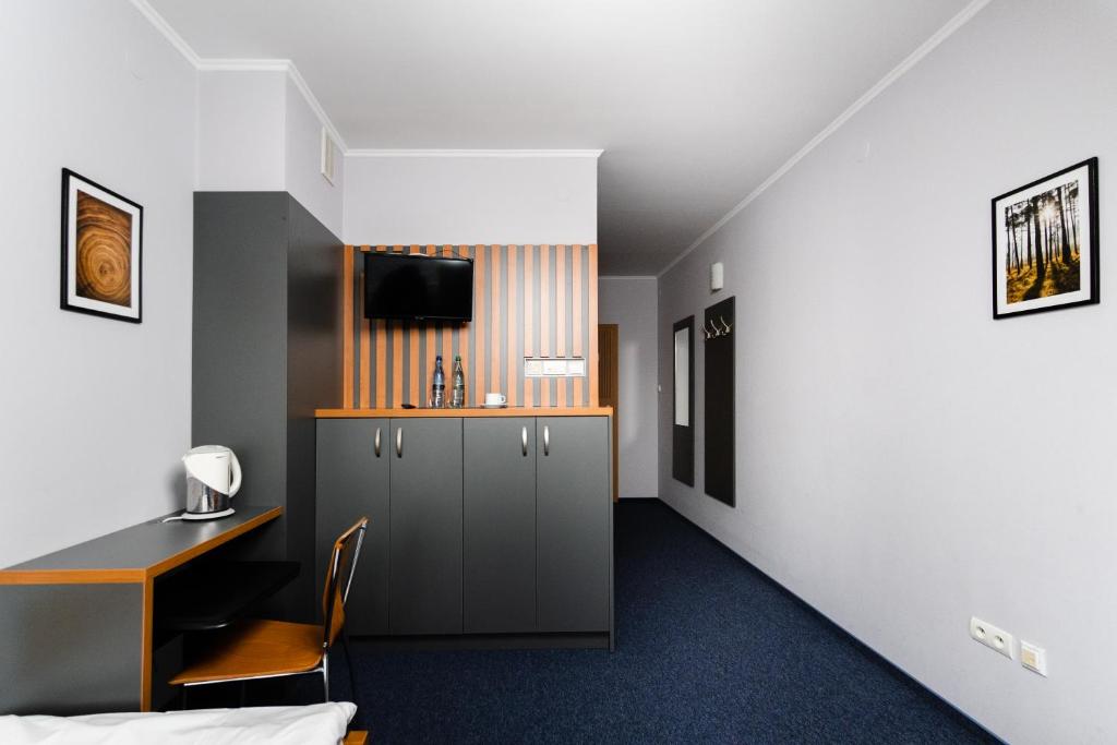 a hotel room with a bed and a desk and a tv at Karpackie Pokoje in Krosno