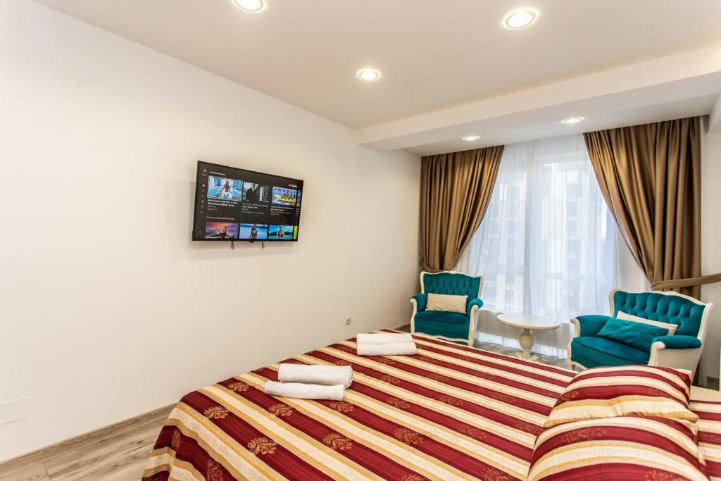 - une chambre avec un grand lit et deux chaises bleues dans l'établissement Star Rent Decebal 99H, à Chişinău