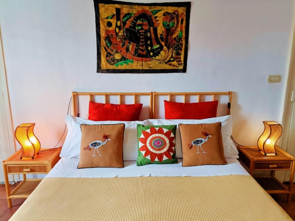 卡塔尼亞的住宿－伊瓦納住宿加早餐酒店，一张带枕头的床和墙上的绘画