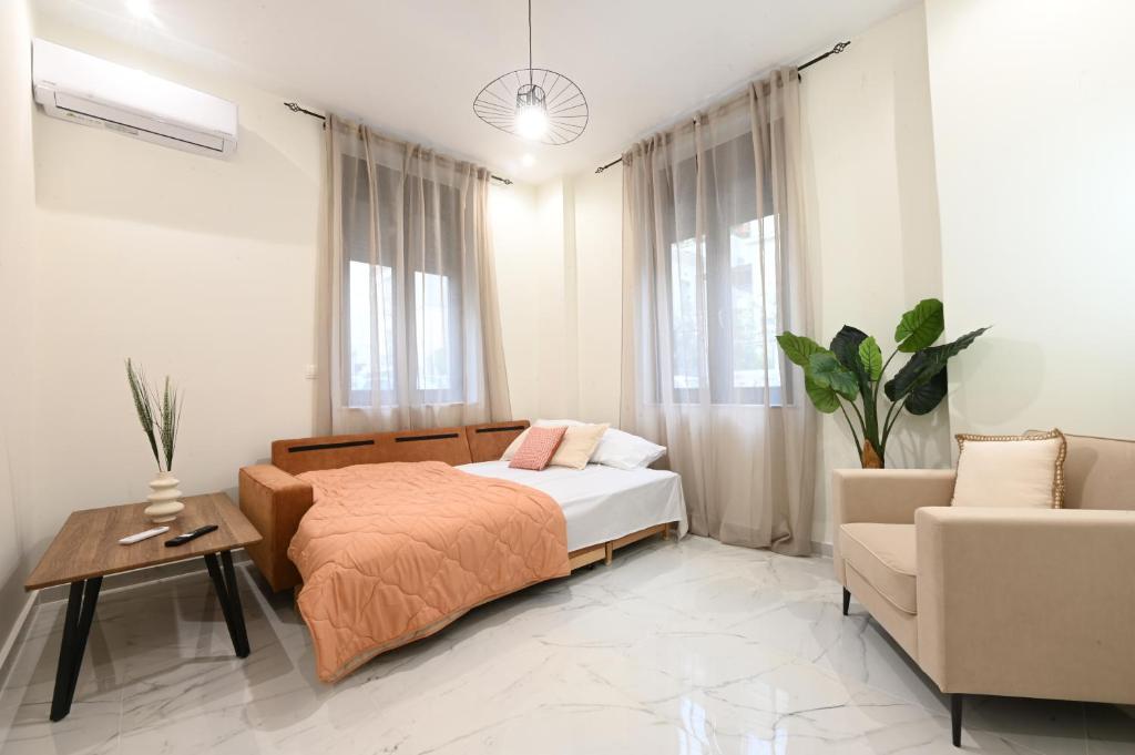 een slaapkamer met een bed, een bank en een tafel bij Modh Patras City Centre - Entire flat in Patra