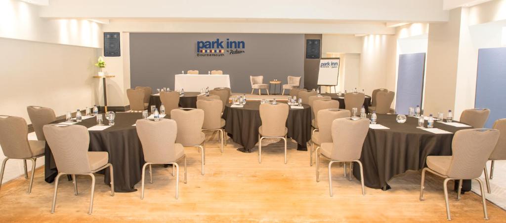 a conference room with tables and chairs and a screen at Park Inn by Radisson Bournemouth in Bournemouth
