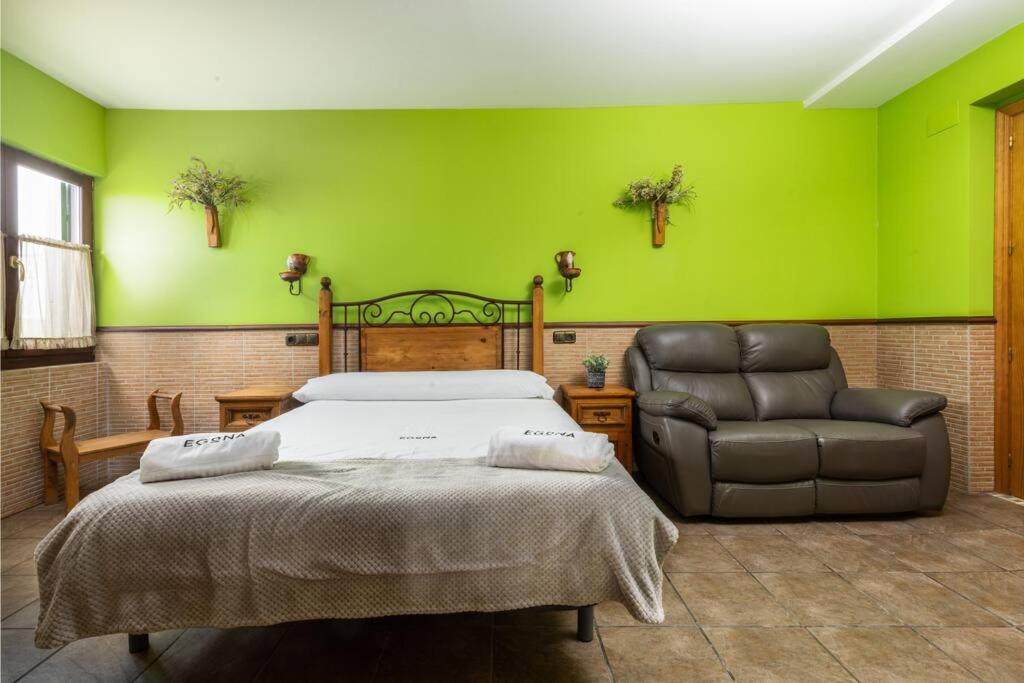 sypialnia z zielonymi ścianami, łóżkiem i krzesłem w obiekcie PERRATZU LANDARBIDE-Ideal parejas w mieście Aia