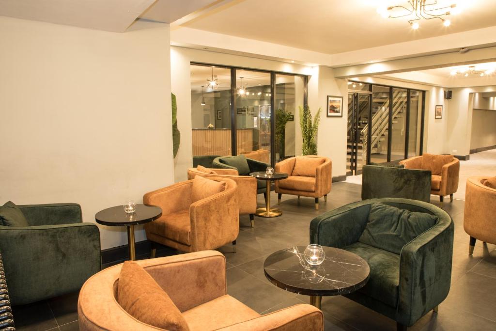 a lobby with couches tables and chairs at Park Inn by Radisson Bournemouth in Bournemouth