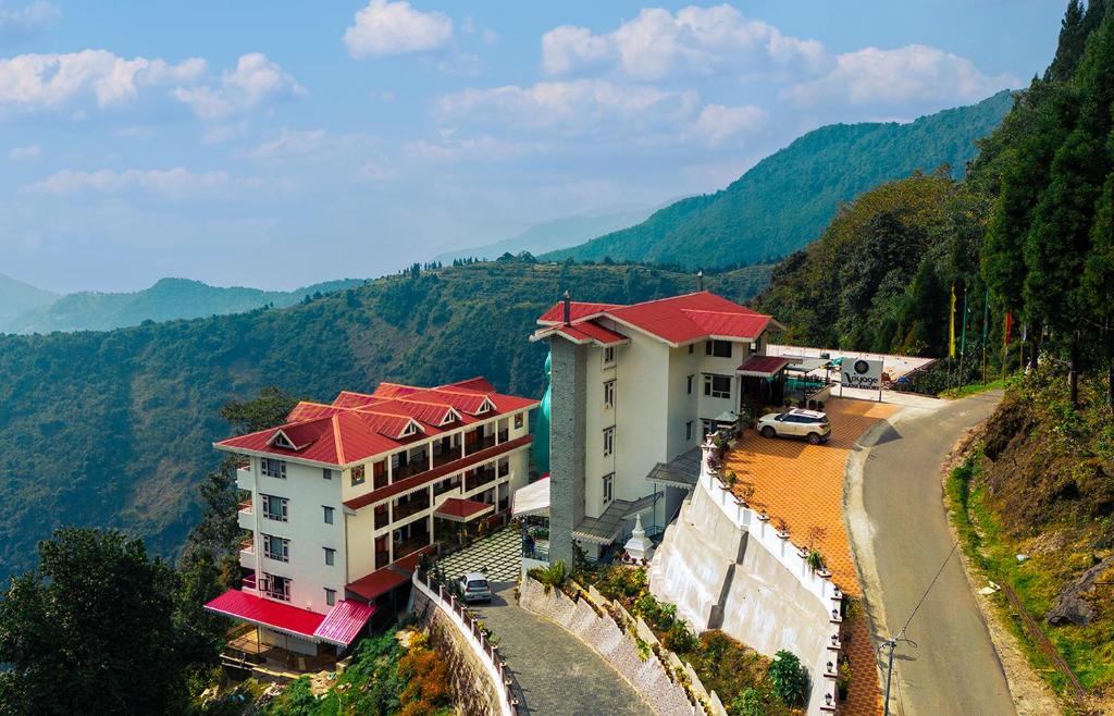 a building on the side of a hill with a road at Voyage Glenz Resort in Pakyong