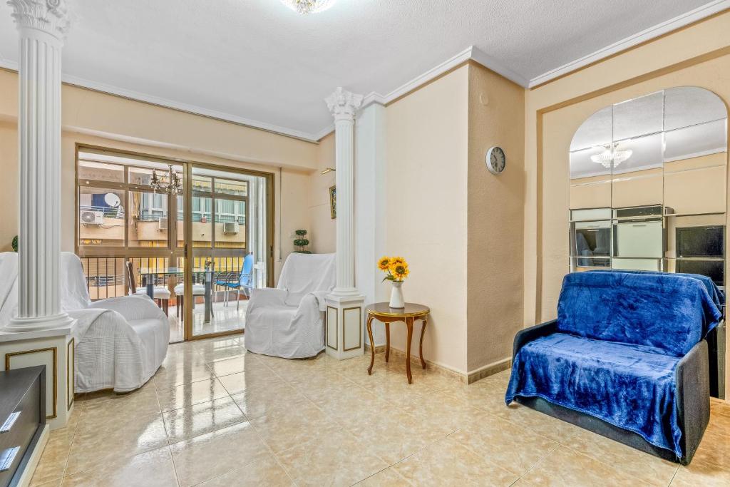 salon z niebieskim krzesłem i stołem w obiekcie Sunflower Alhambra w mieście Santa Pola