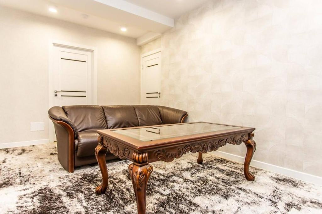 a living room with a leather couch and a coffee table at Starrent Decebal 99F in Chişinău