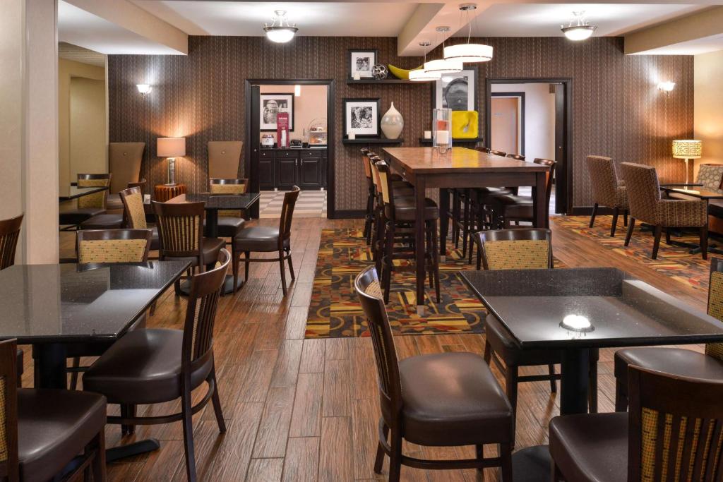 a restaurant with tables and chairs and a bar at Wingate by Wyndham Steubenville in Steubenville