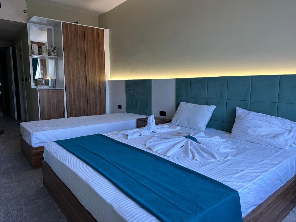 Kançul Hotel Taştepeler في سانليورفا: غرفة نوم بسريرين مع شراشف بيضاء