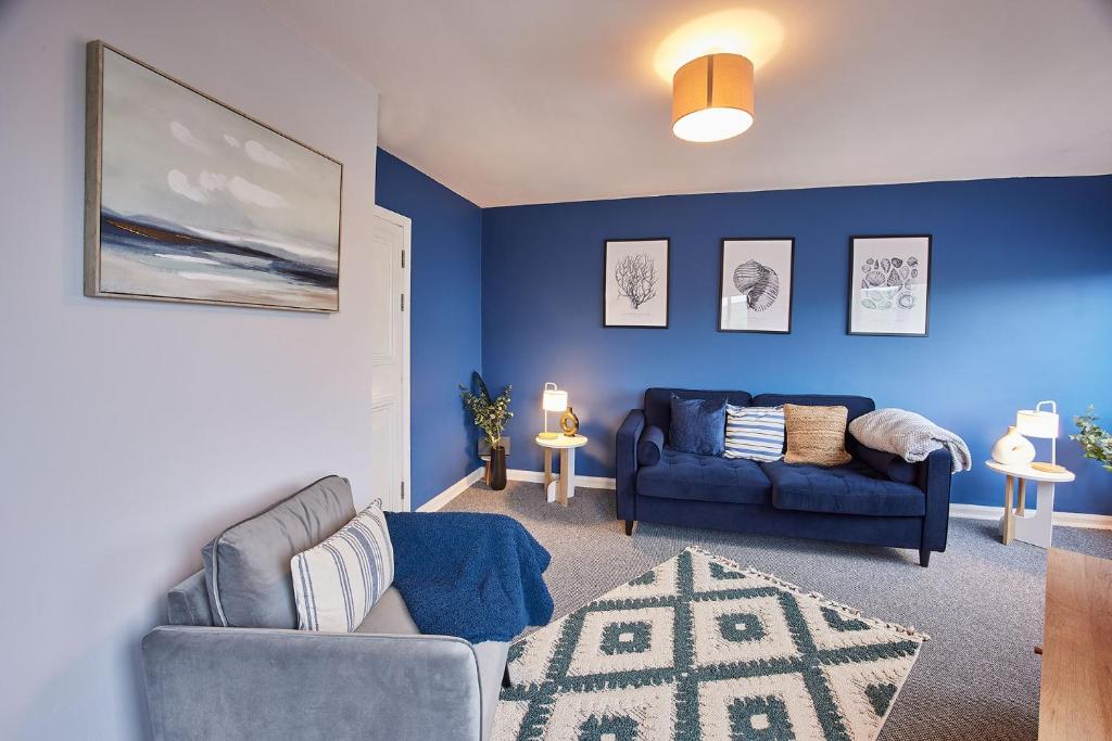 sala de estar con paredes azules y sofá azul en Seaside Retreat sleeping 4 en Ilfracombe